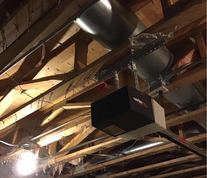 Open ceiling showing the studs above a garage door opener.
